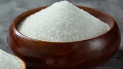 A bowl of white cane sugar crystals, emphasizing Kirana King’s meticulous selection of premium-quality food grains, purity, and commitment to delivering trusted staples through careful sourcing and emphasis on superior grocery standards.