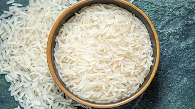 A bowl of uncooked basmati rice with scattered grains, emphasizing Kirana King’s meticulous selection of premium-quality food grains, purity, and commitment to delivering trusted staples through careful sourcing and emphasis on superior grocery standards.